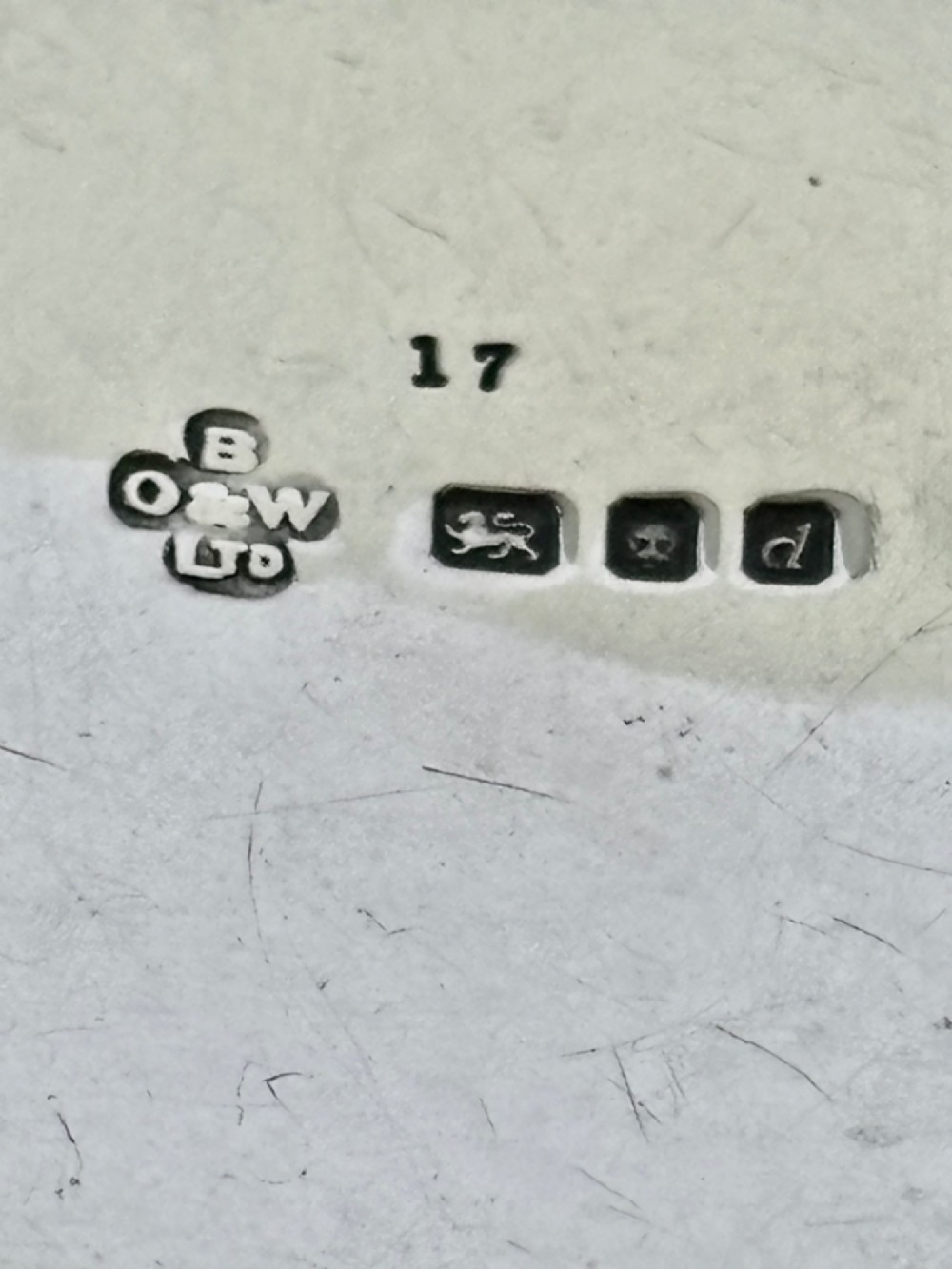 A small round sterling silver pyx box shown open, featuring a silver exterior and a gold-gilt interior stamped with hallmarks. View IV