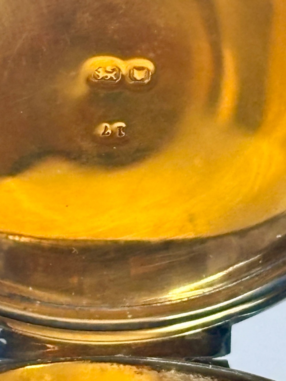 A small round sterling silver pyx box shown open, featuring a silver exterior and a gold-gilt interior stamped with hallmarks. View IX
