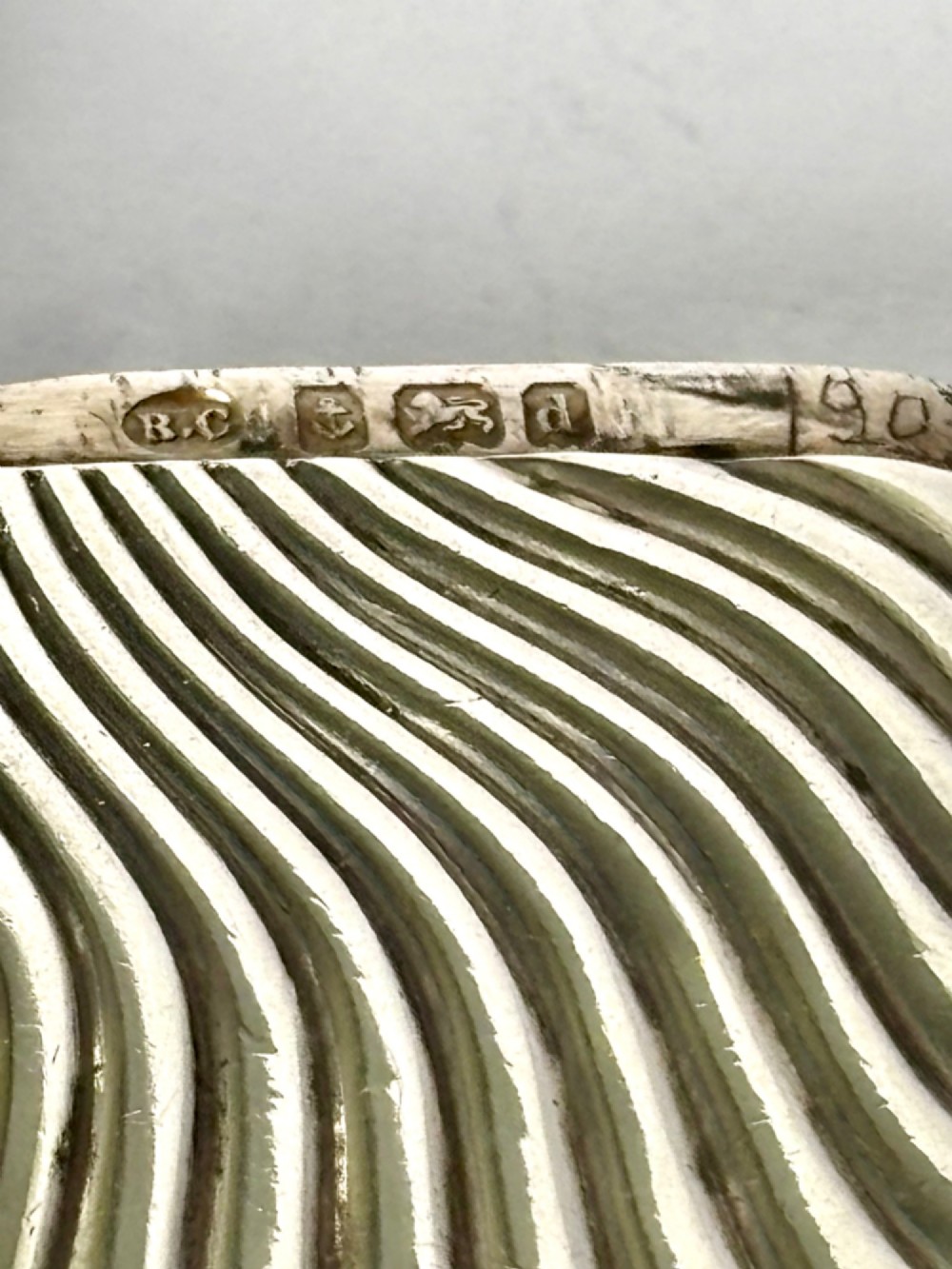 An Edwardian sterling silver pocket vesta case featuring a raised sunburst design with radiating swirled fluting and a side suspension ring. View VI