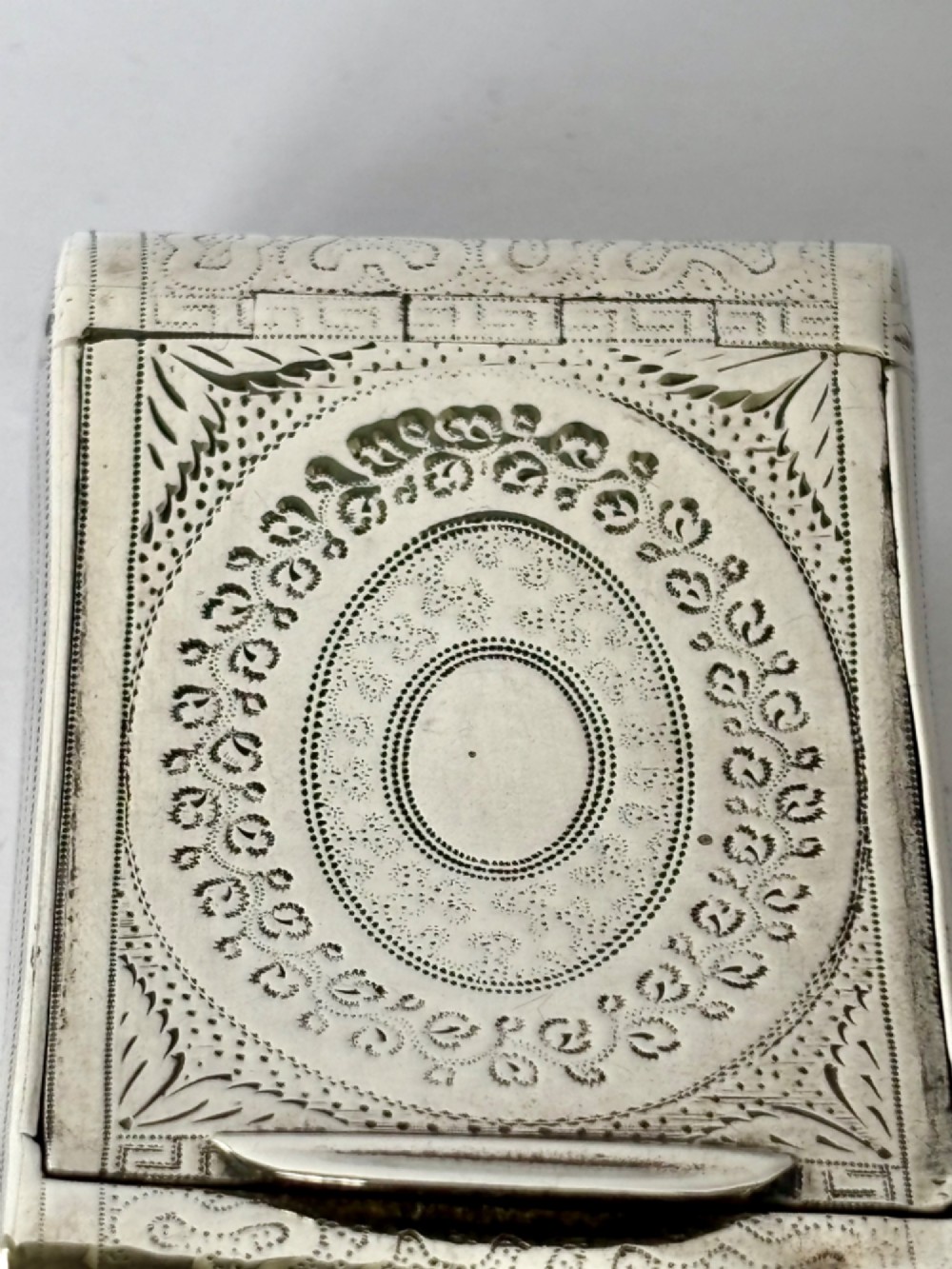 A curved antique sterling silver pocket snuff box featuring elaborate hand engraving and a flush hinge. View IV