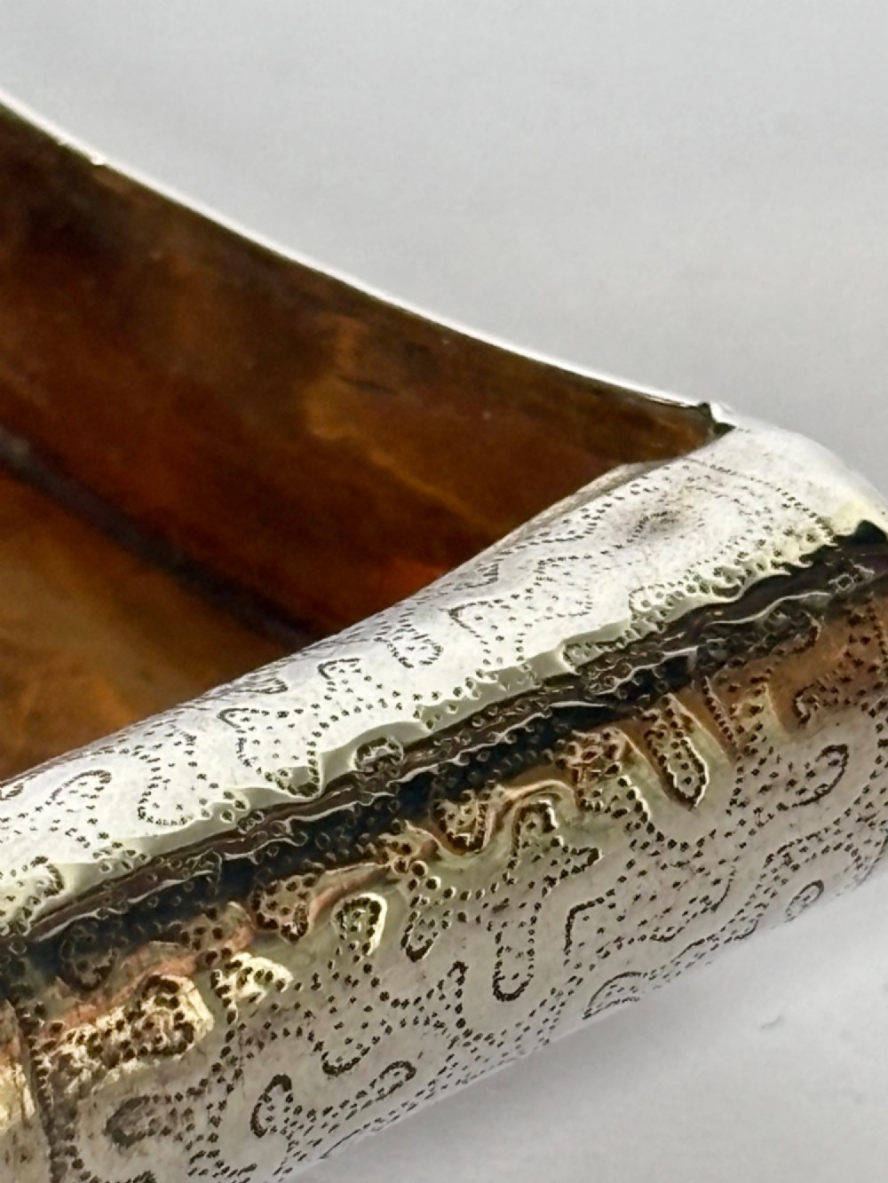 A curved antique sterling silver pocket snuff box featuring elaborate hand engraving and a flush hinge. View XIV