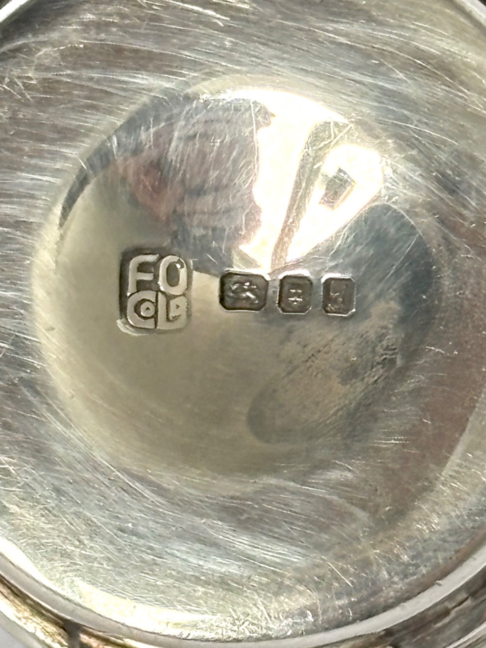 A circular sterling silver pyx box with a polished finish, featuring a lid topped with a cross and orb finial. View VII