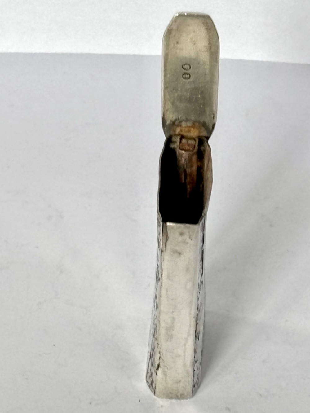 An upright rectangular Victorian sterling silver vesta case with hand-engraved leaf patterns, a central monogrammed oval cartouche, and prominent Birmingham hallmark stamps. View IX