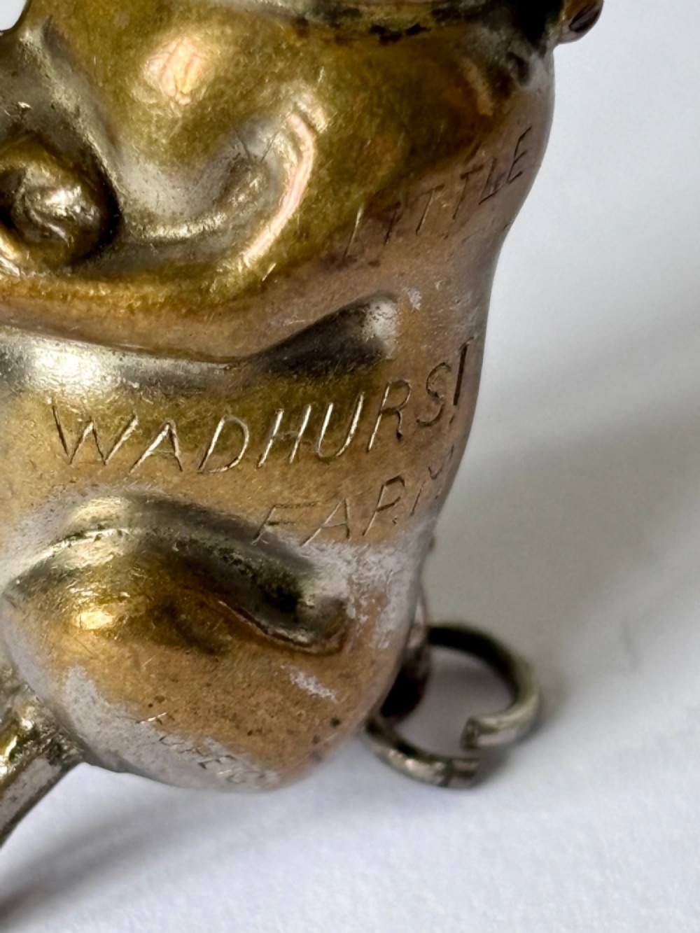 A small antique cast brass vesta case formed in the shape of a pig sitting upright. View II