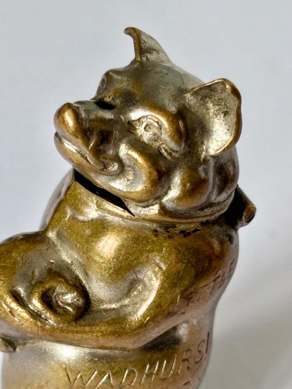 A small antique cast brass vesta case formed in the shape of a pig sitting upright. View V