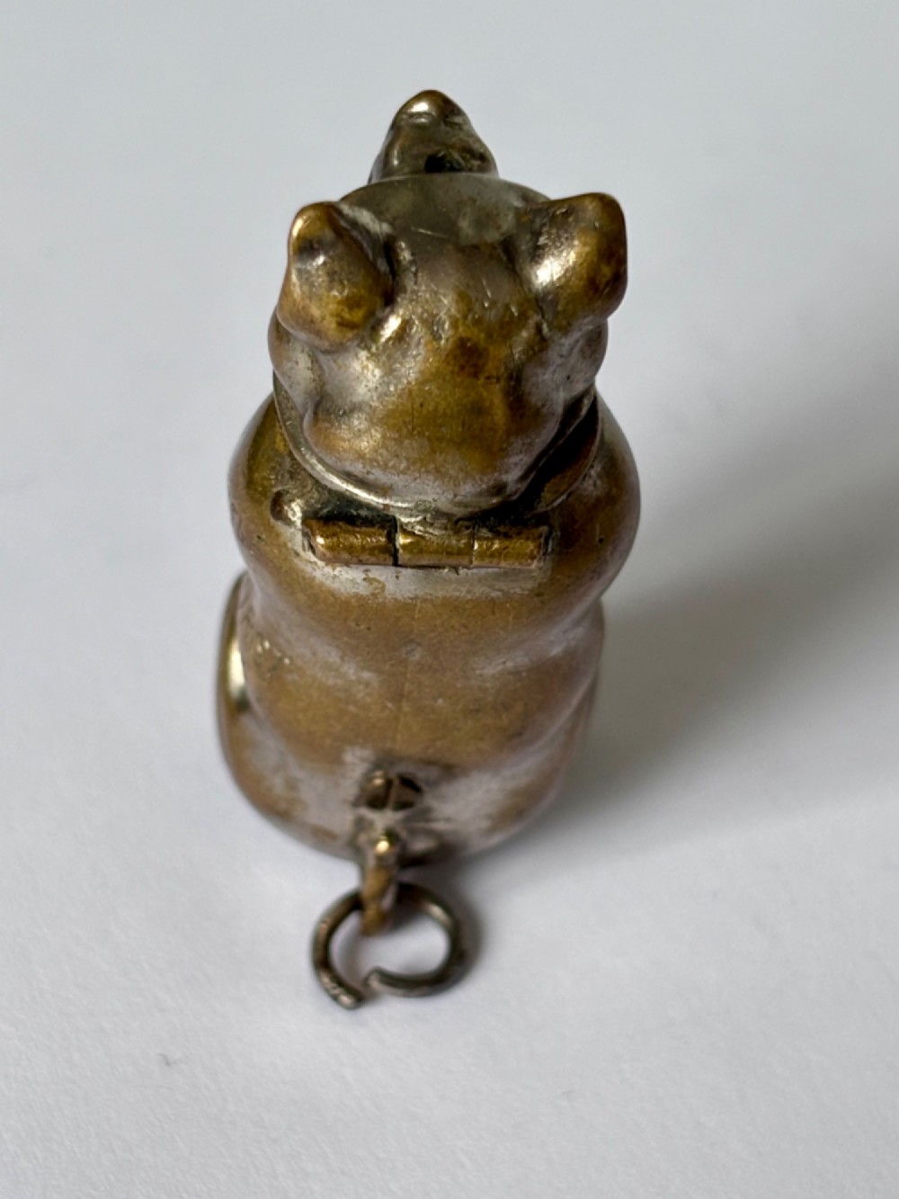 A small antique cast brass vesta case formed in the shape of a pig sitting upright. View VI