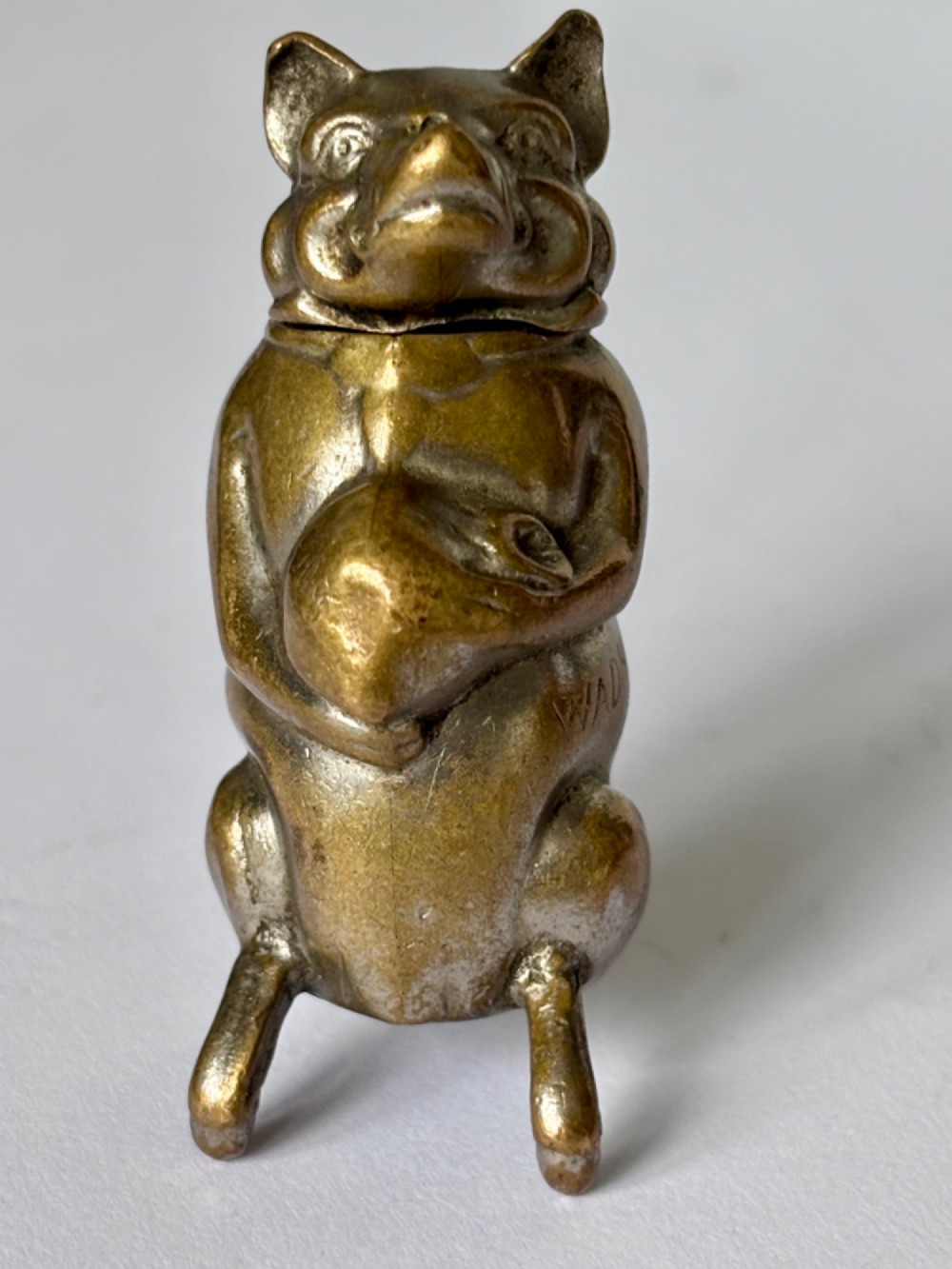 A small antique cast brass vesta case formed in the shape of a pig sitting upright. View VII