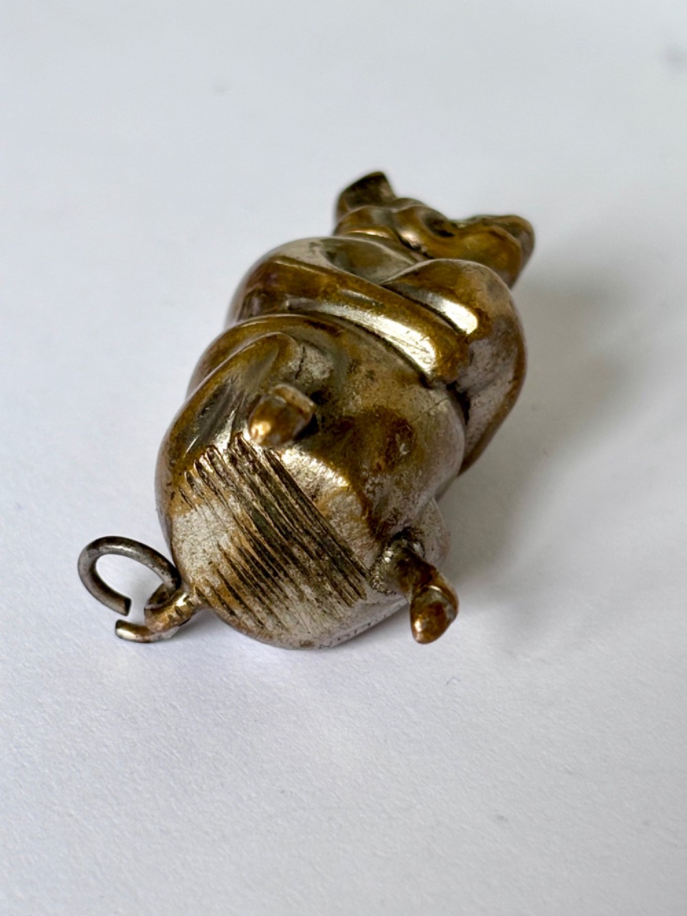 A small antique cast brass vesta case formed in the shape of a pig sitting upright. View X