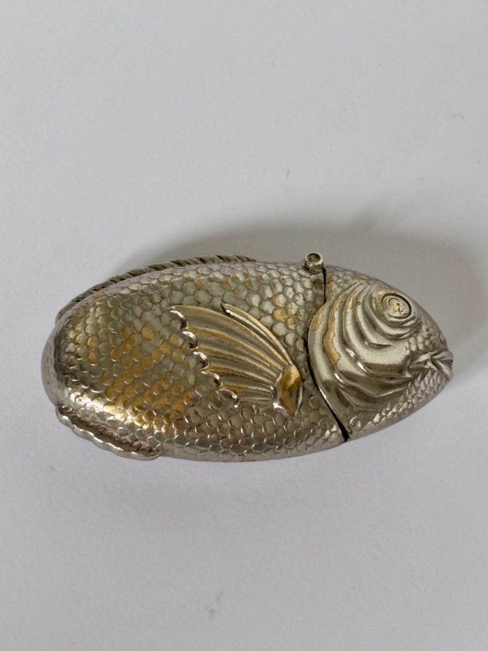 A silver-plated brass vesta case cast in the shape of a carp with detailed body scales and a hinged head. View II