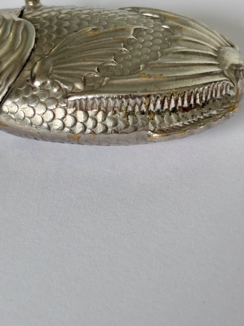 A silver-plated brass vesta case cast in the shape of a carp with detailed body scales and a hinged head. View III