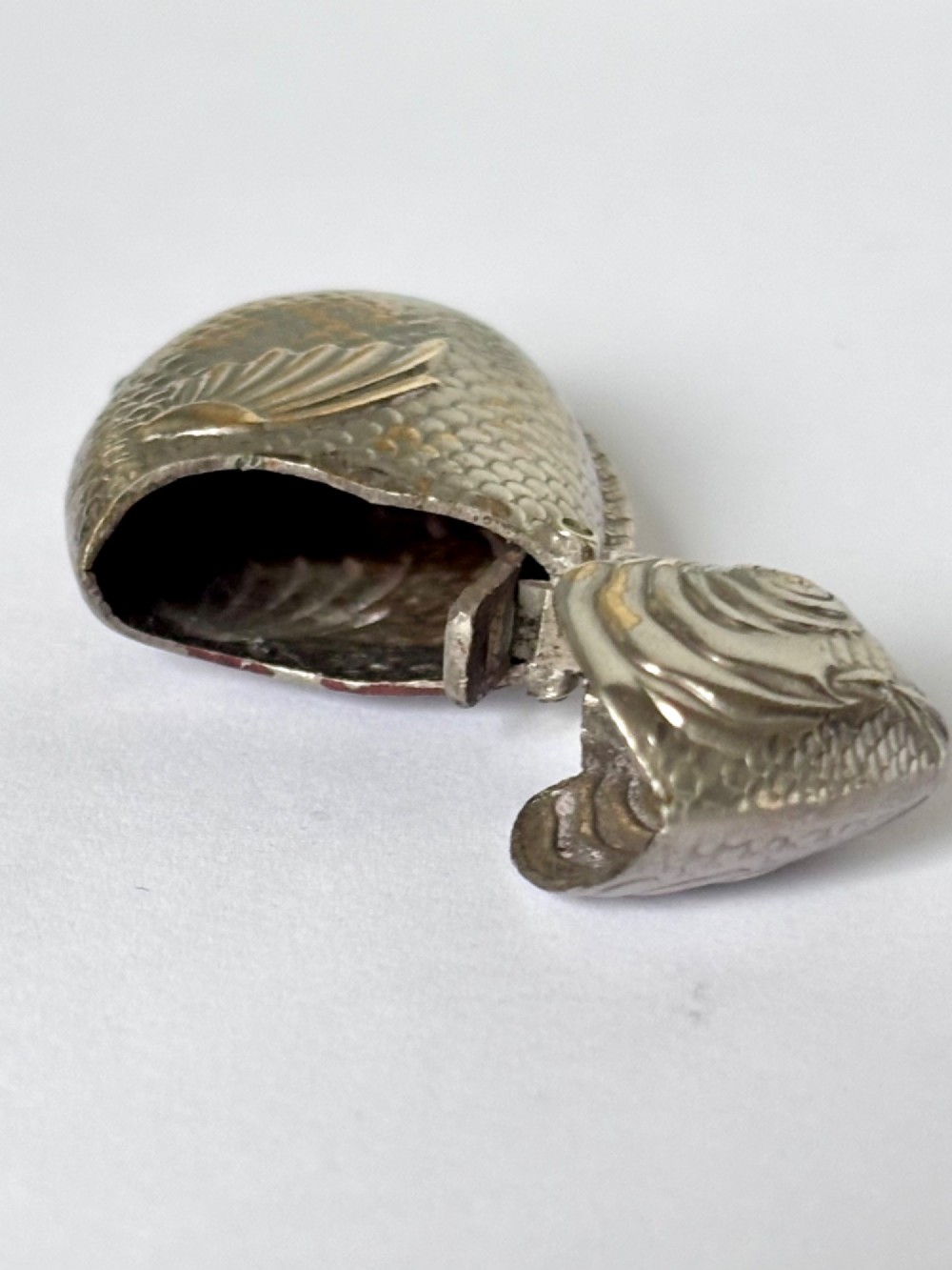 A silver-plated brass vesta case cast in the shape of a carp with detailed body scales and a hinged head. View VII