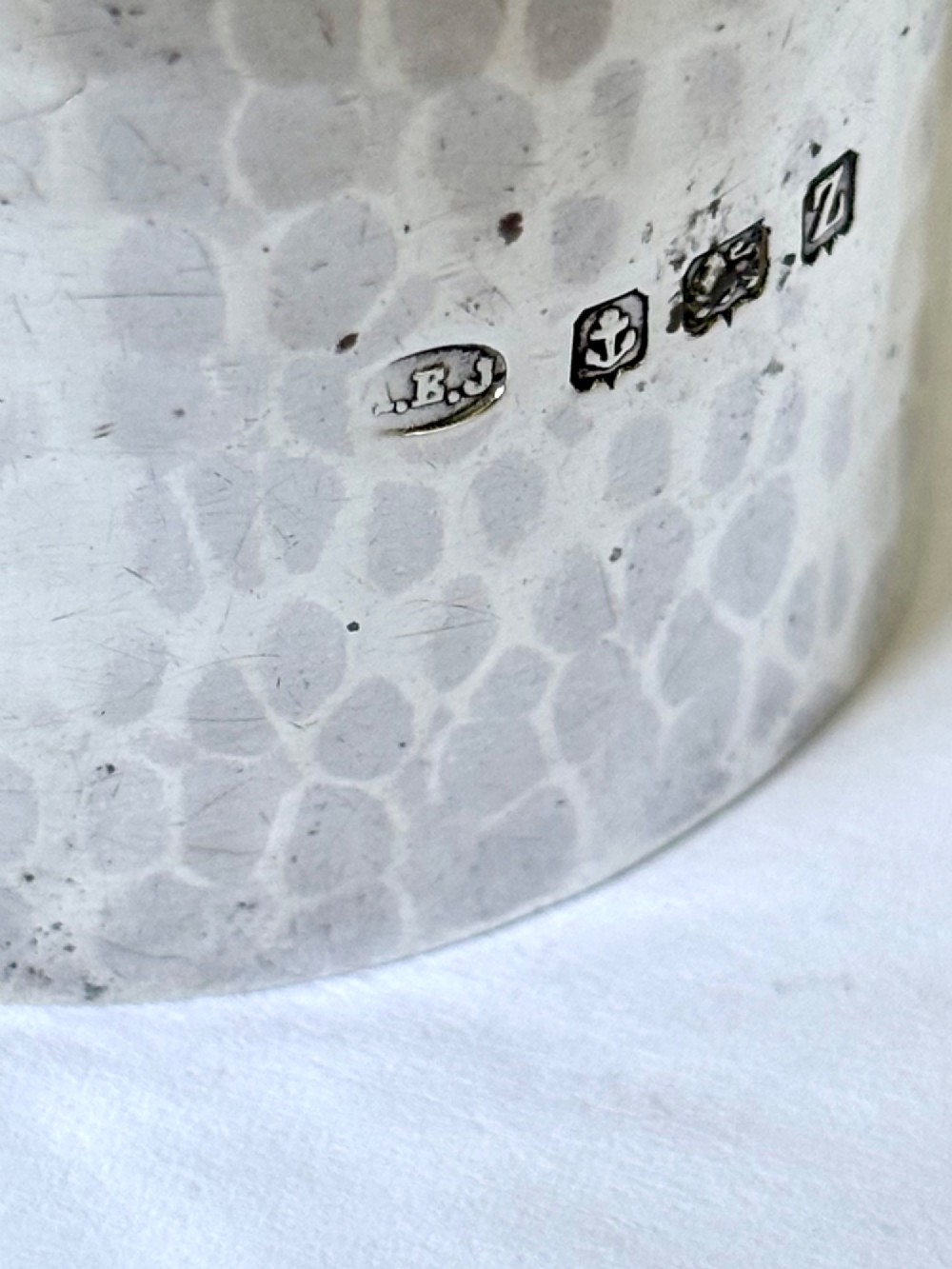 A wide, cylindrical sterling silver napkin ring featuring a hand-hammered planished surface finish. View IV