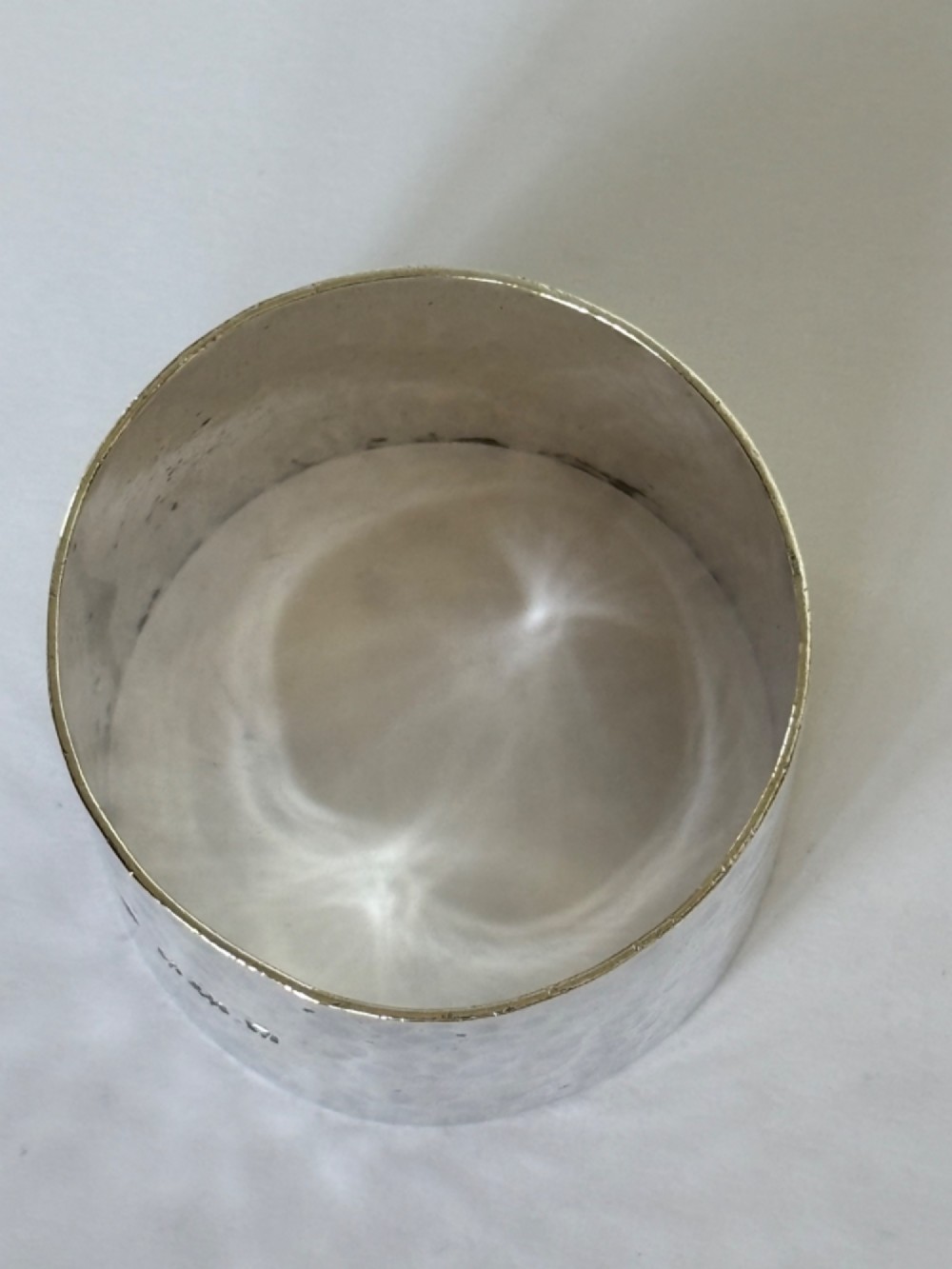 A wide, cylindrical sterling silver napkin ring featuring a hand-hammered planished surface finish. View VI