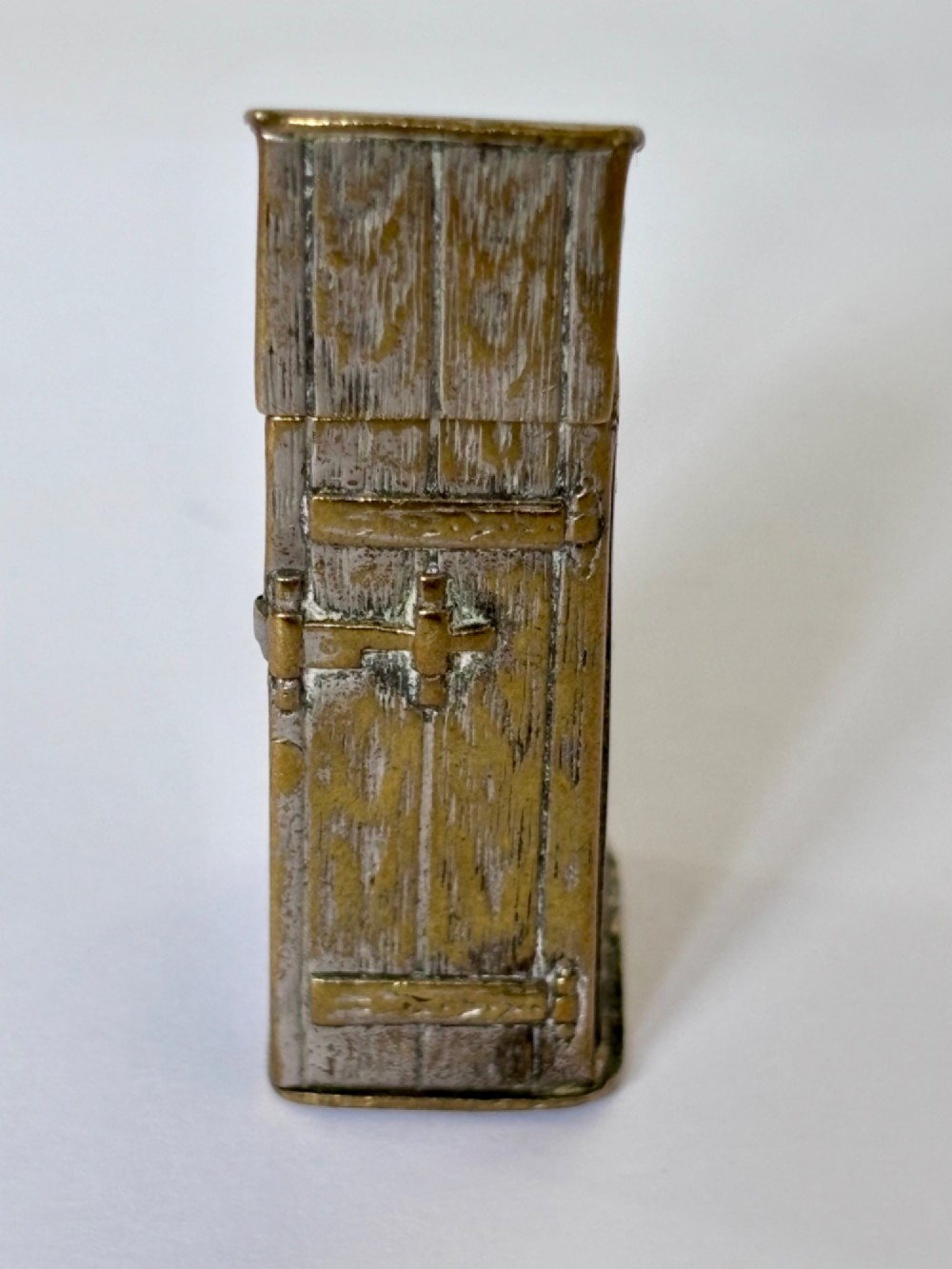 An antique Victorian brass novelty vesta case designed as an outhouse with an opening door revealing a gentleman seated inside. View II