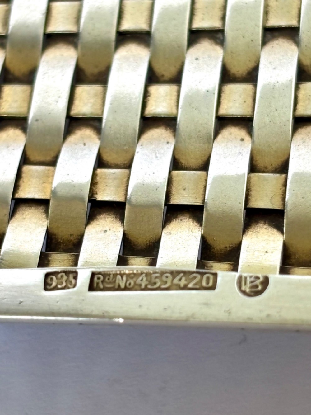 An early 20th-century rectangular silver cigarette case with a textured basketweave pattern and a side release button. View V