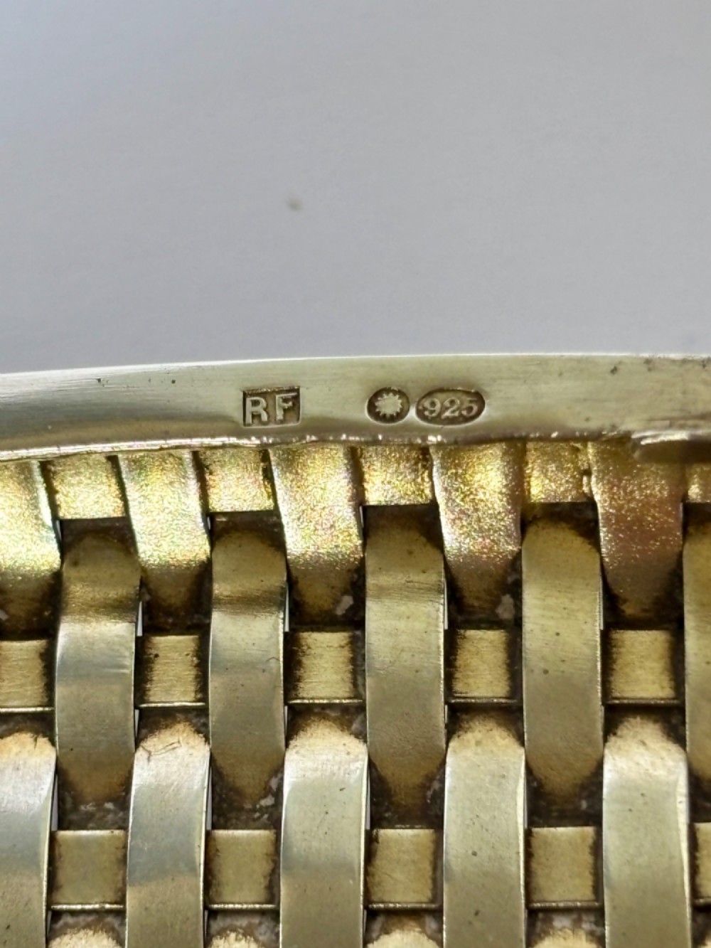 An early 20th-century rectangular silver cigarette case with a textured basketweave pattern and a side release button. View VII