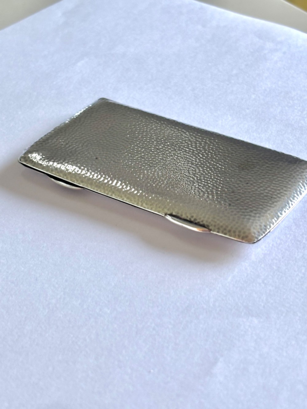 A slimline rectangular sterling silver card case featuring a hand-hammered planished surface texture.