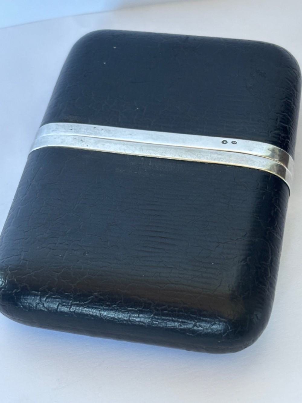 An antique black textured leather cigar case featuring a central hallmarked 900 silver collar. View V