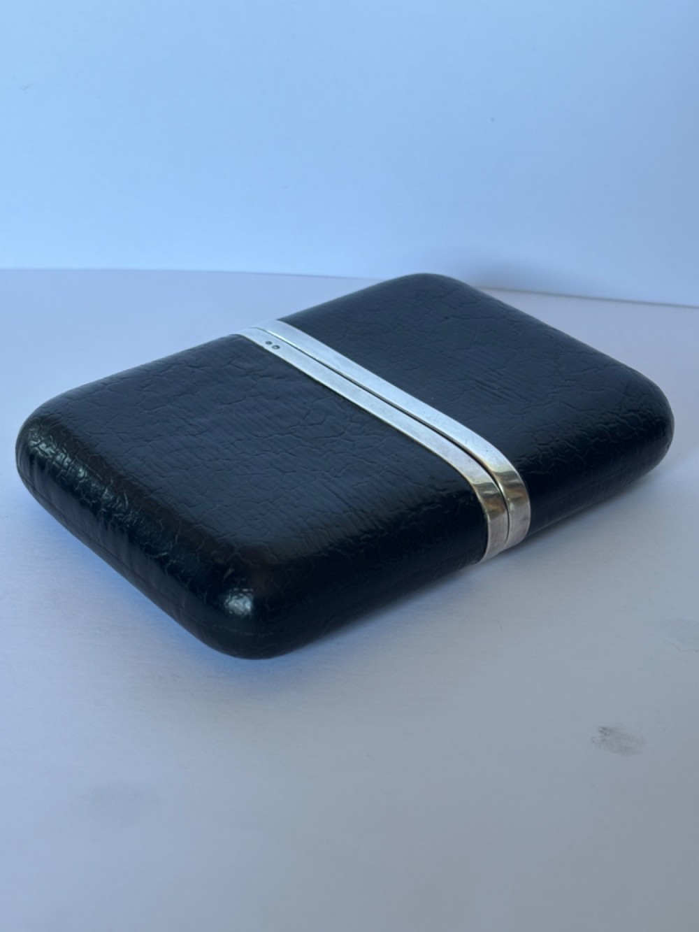 An antique black textured leather cigar case featuring a central hallmarked 900 silver collar. View VI