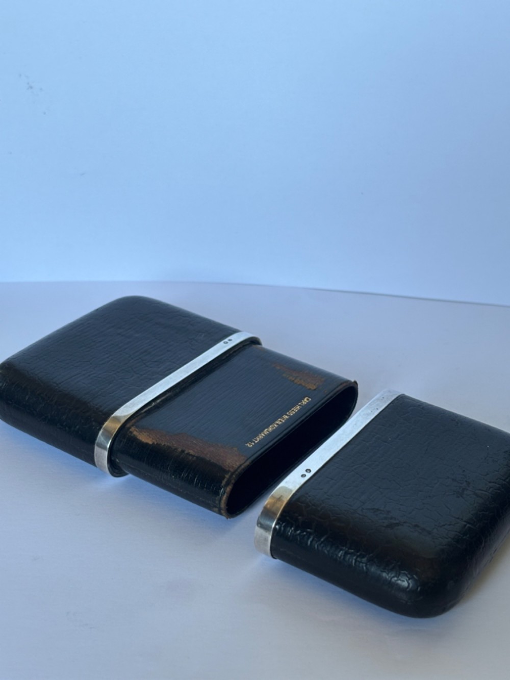 An antique black textured leather cigar case featuring a central hallmarked 900 silver collar. View VII