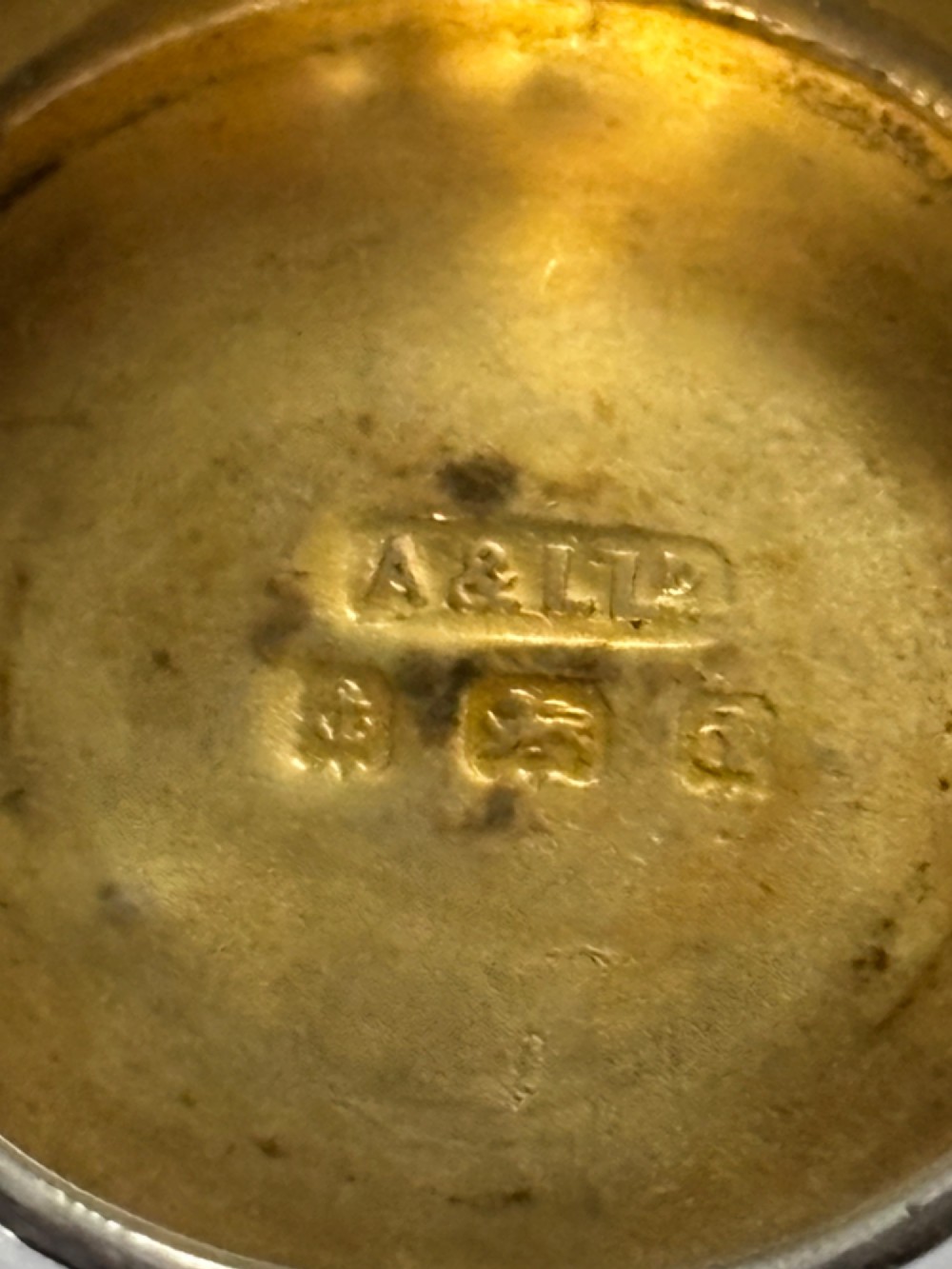 A small circular Edwardian sterling silver gilt trinket box with embossed scrollwork decoration on the lid. View III