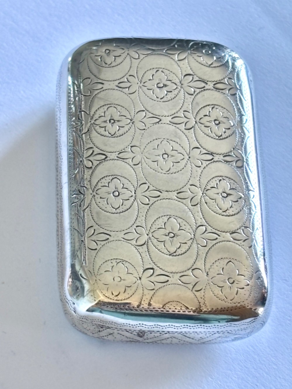 A small rectangular George III sterling silver snuff box with bright-cut floral engraving and a central oval cartouche. View III