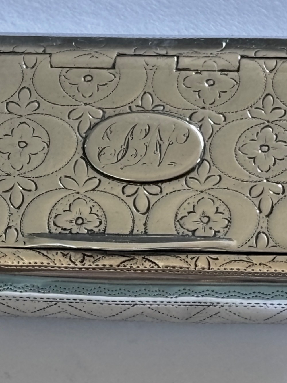 A small rectangular George III sterling silver snuff box with bright-cut floral engraving and a central oval cartouche. View V