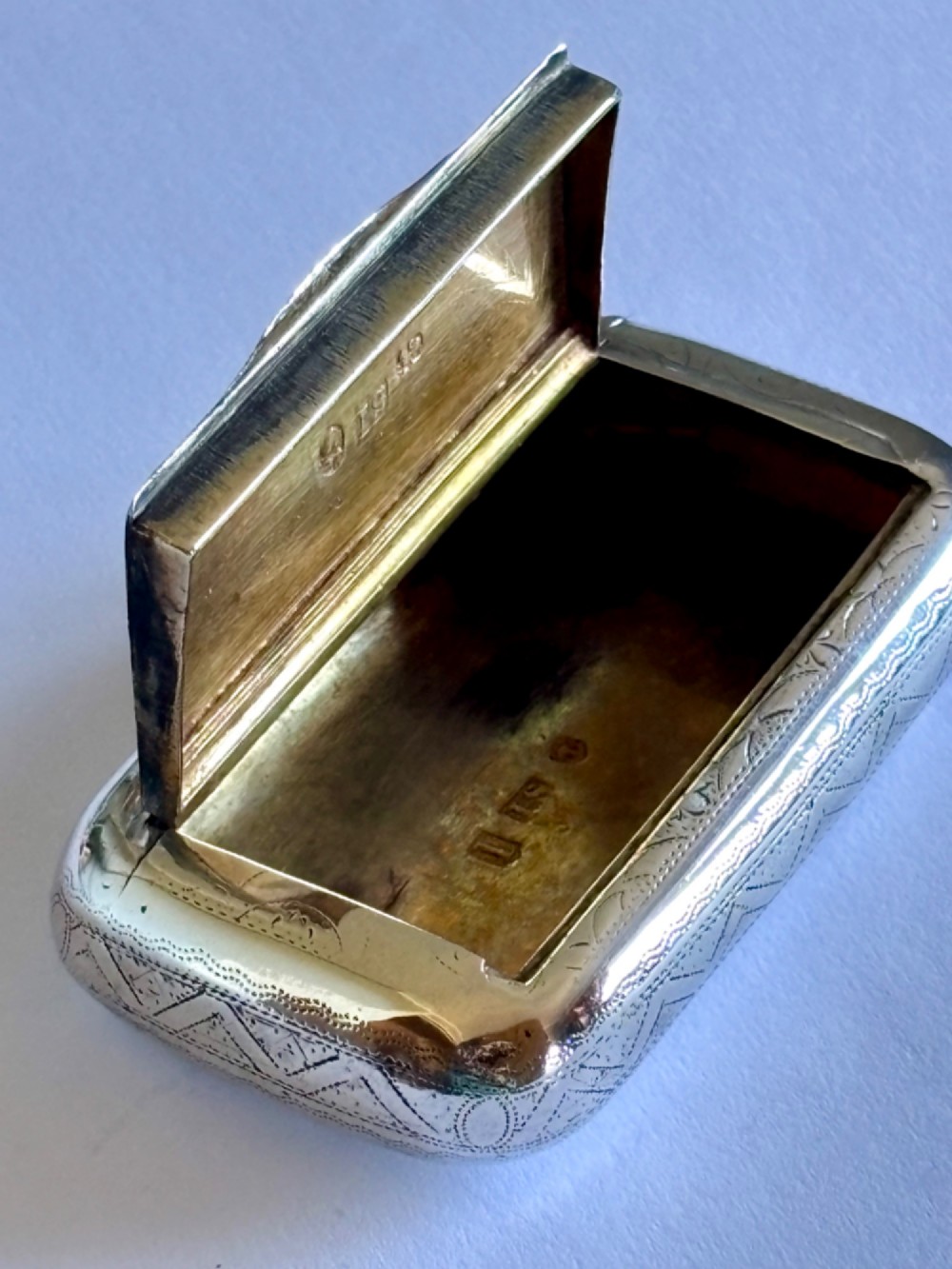 A small rectangular George III sterling silver snuff box with bright-cut floral engraving and a central oval cartouche. View VI