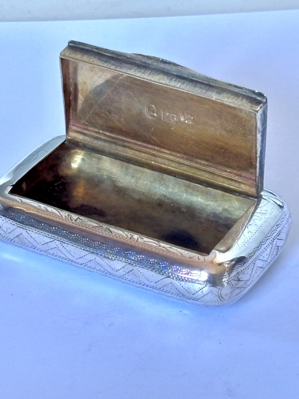 A small rectangular George III sterling silver snuff box with bright-cut floral engraving and a central oval cartouche. View VII