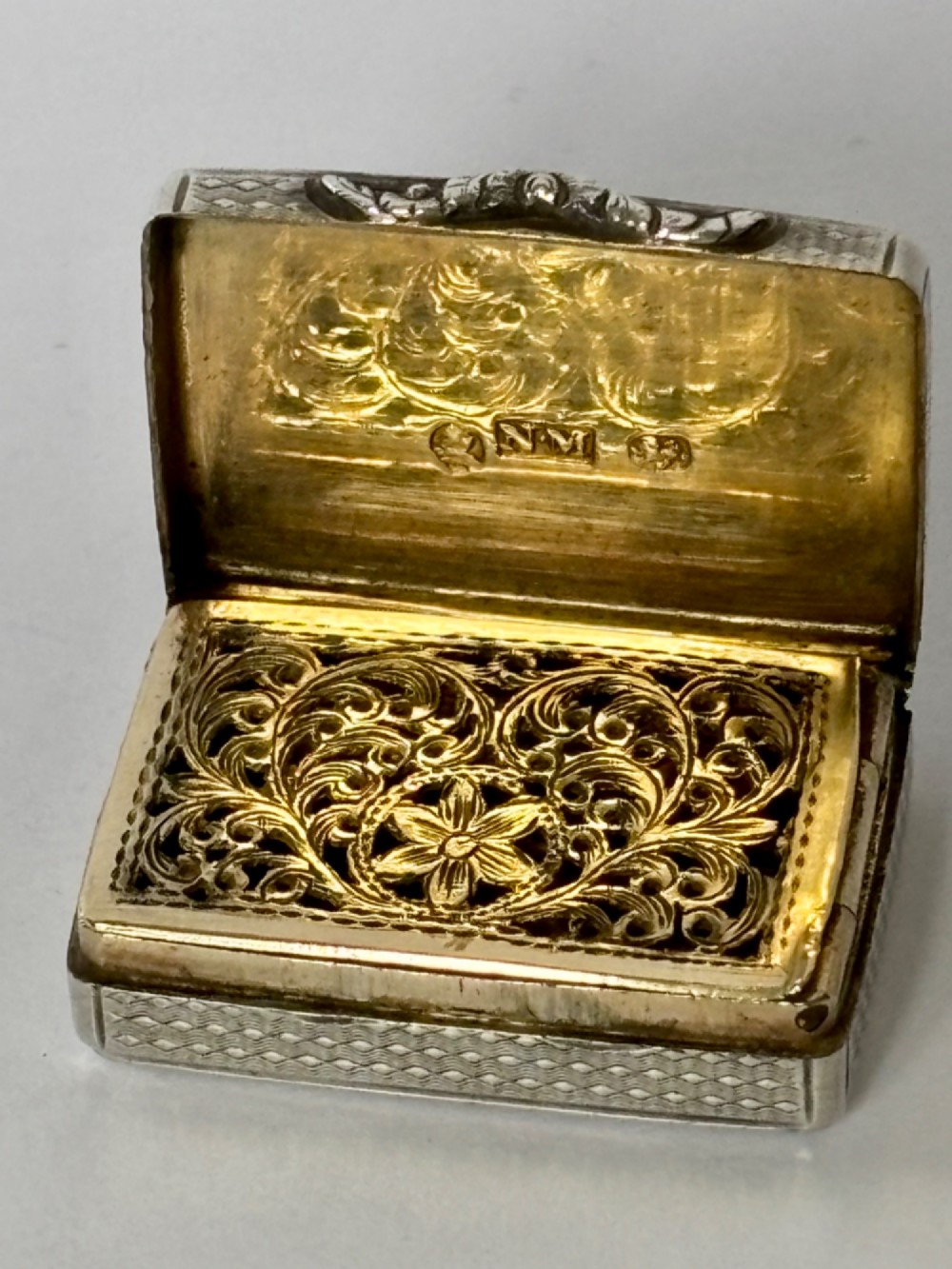 A small open rectangular silver-gilt box featuring a finely pierced floral inner grille and engraved lid detailing. View II