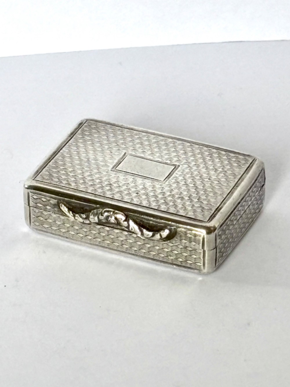 A small open rectangular silver-gilt box featuring a finely pierced floral inner grille and engraved lid detailing. View V