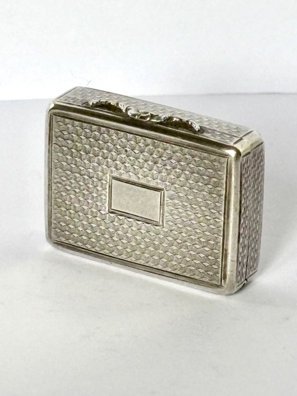 A small open rectangular silver-gilt box featuring a finely pierced floral inner grille and engraved lid detailing. View VII