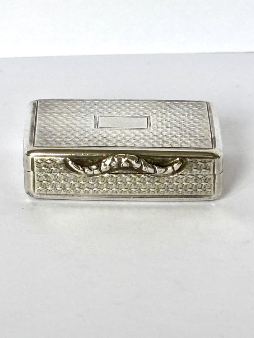 A small open rectangular silver-gilt box featuring a finely pierced floral inner grille and engraved lid detailing. View IX