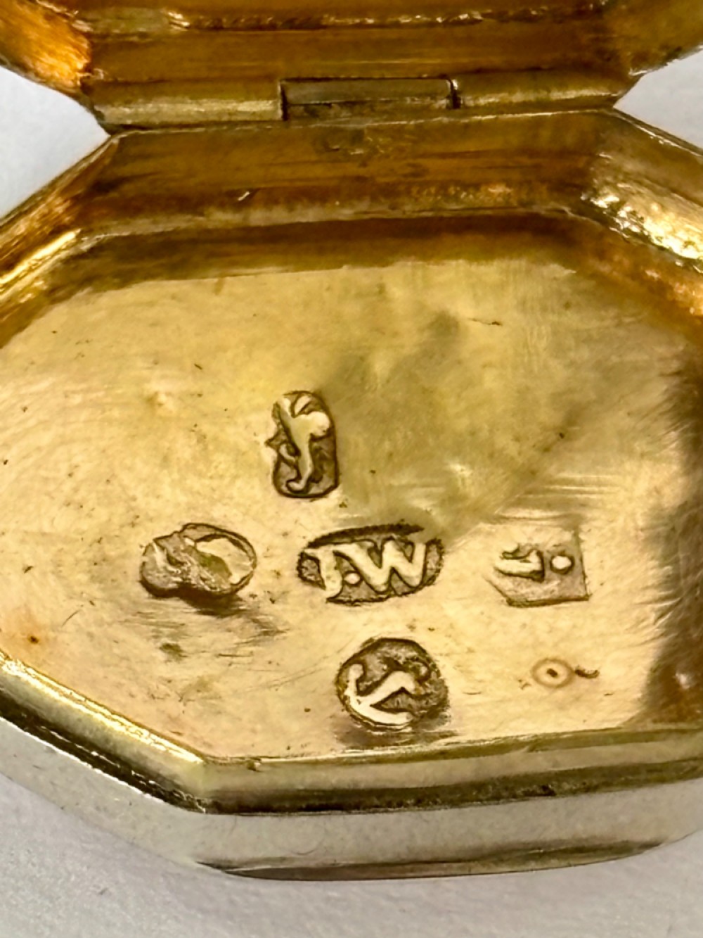 An open George III octagonal sterling silver vinaigrette displaying a gilded interior with a perforated cover and makers stamp. View II