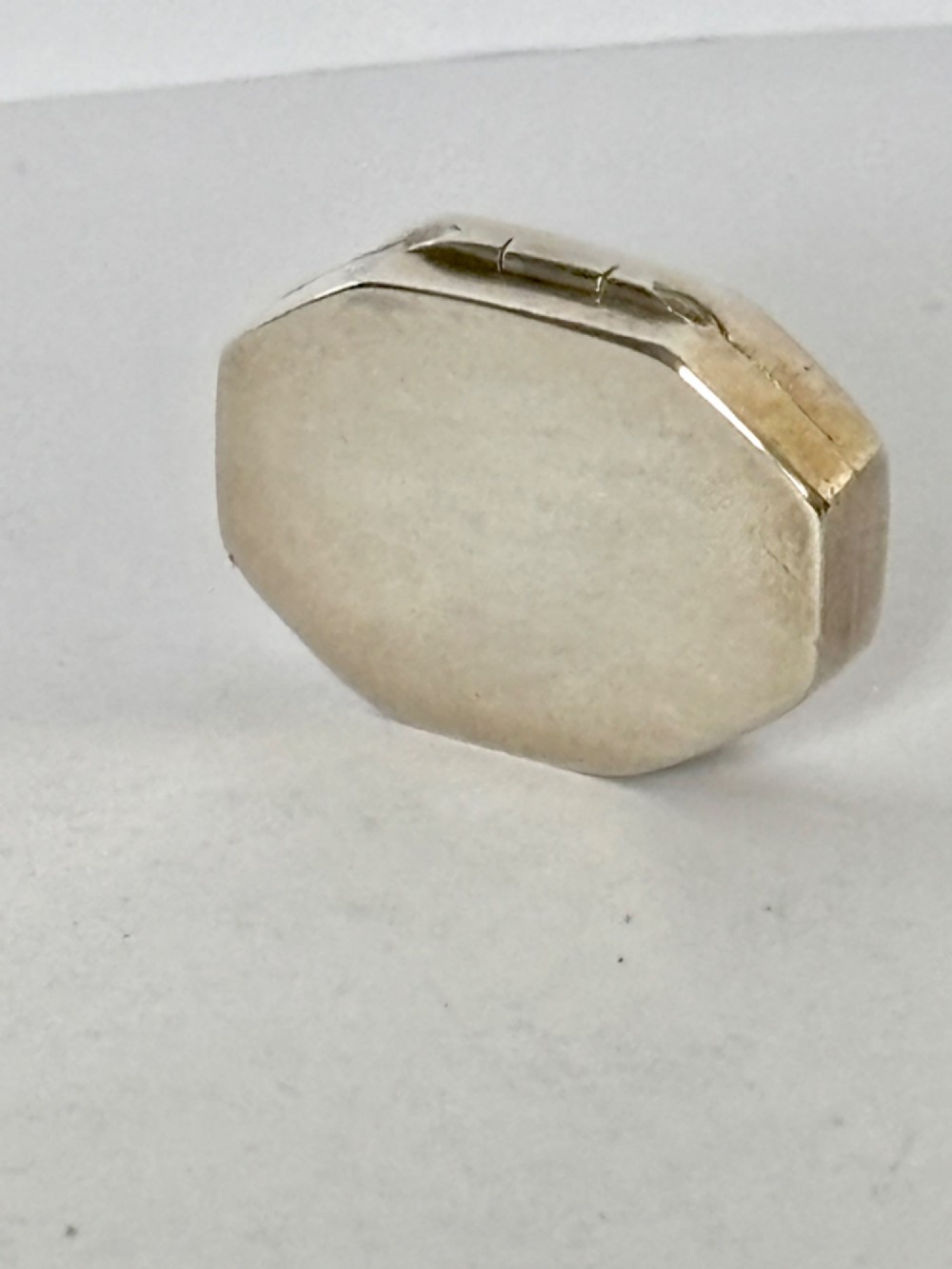 An open George III octagonal sterling silver vinaigrette displaying a gilded interior with a perforated cover and makers stamp. View III
