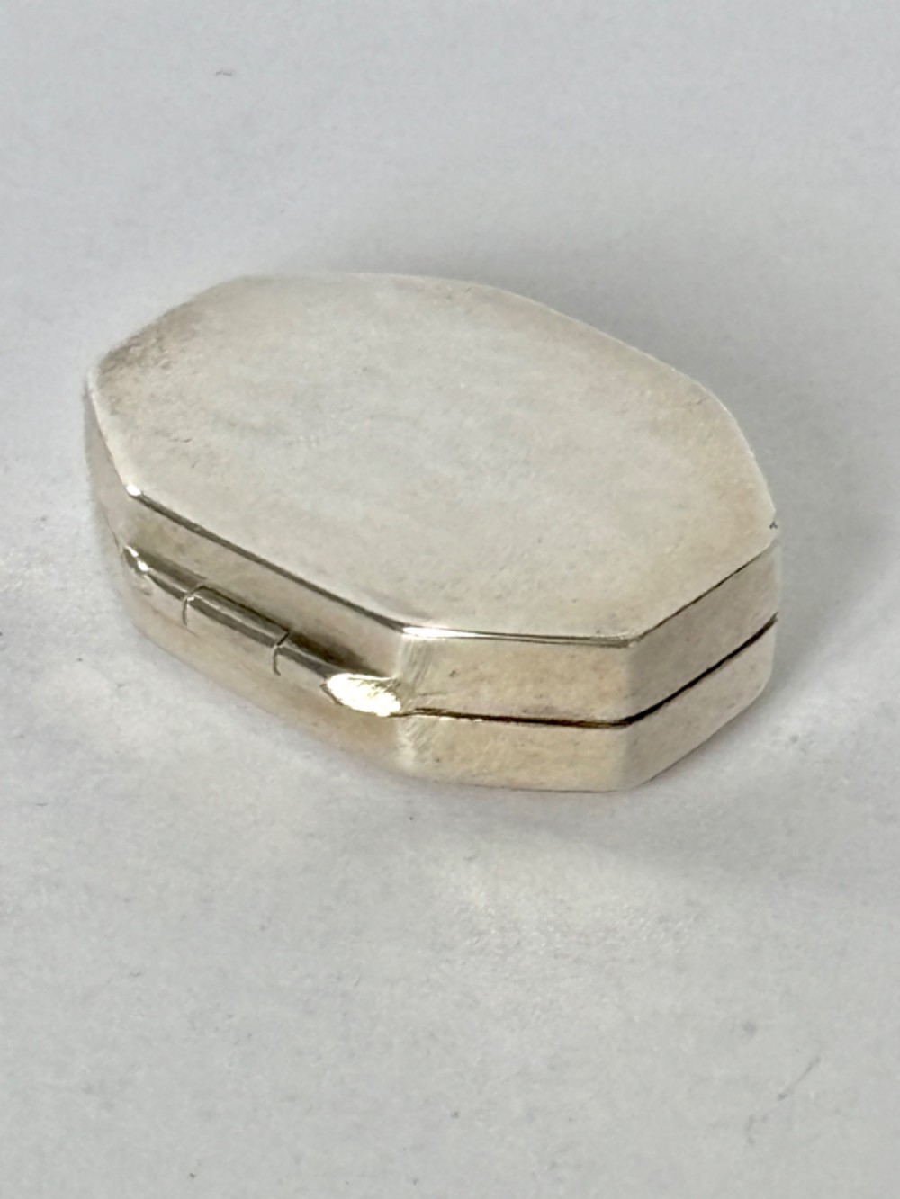 An open George III octagonal sterling silver vinaigrette displaying a gilded interior with a perforated cover and makers stamp. View V