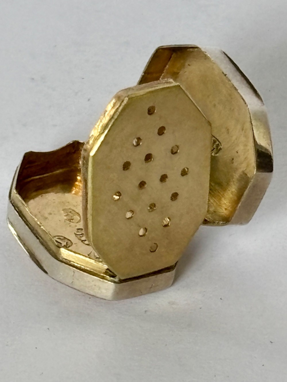 An open George III octagonal sterling silver vinaigrette displaying a gilded interior with a perforated cover and makers stamp. View VI