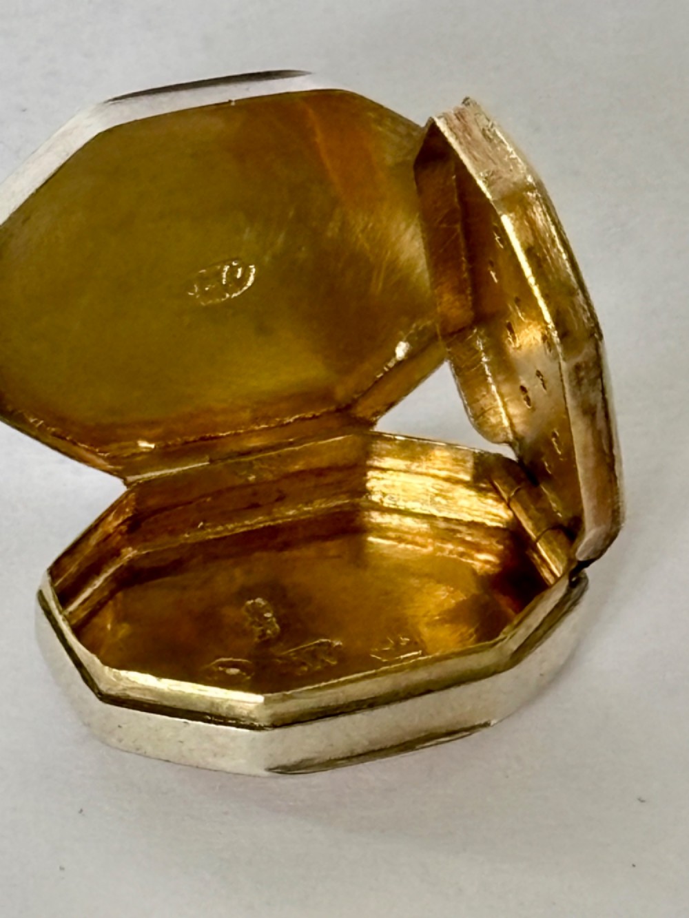 An open George III octagonal sterling silver vinaigrette displaying a gilded interior with a perforated cover and makers stamp. View VIII