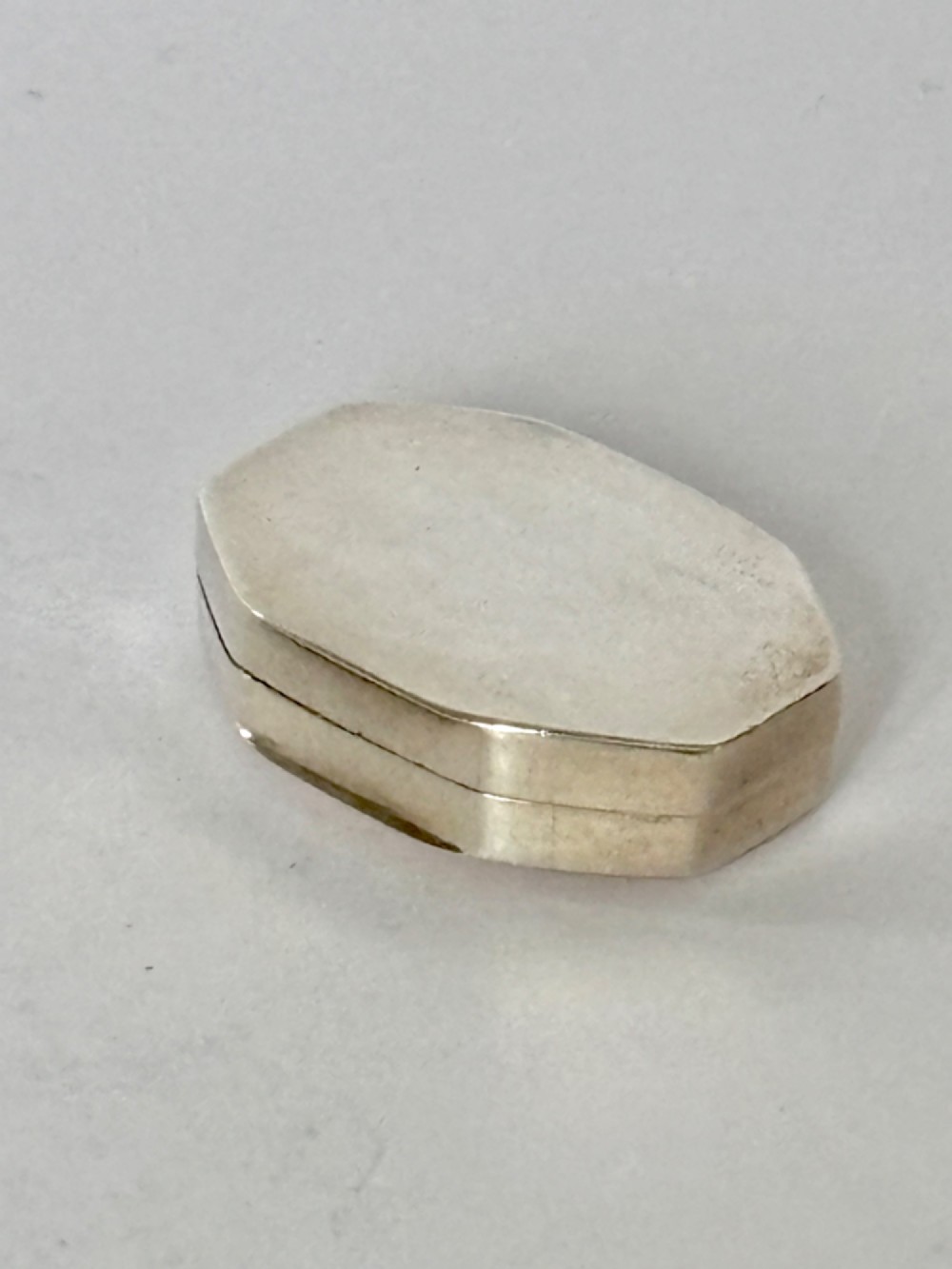 An open George III octagonal sterling silver vinaigrette displaying a gilded interior with a perforated cover and makers stamp. View IX