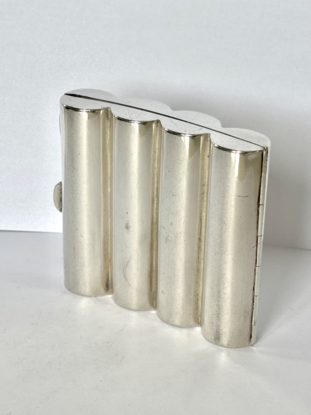 A four-tube sterling silver tobacco cartridge case with a hinged cover and smooth polished finish. View V
