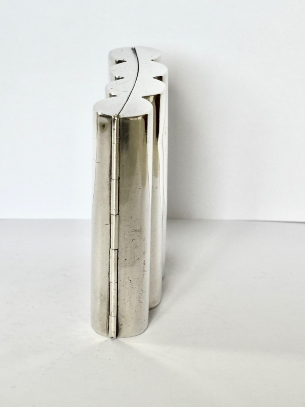 A four-tube sterling silver tobacco cartridge case with a hinged cover and smooth polished finish. View VI