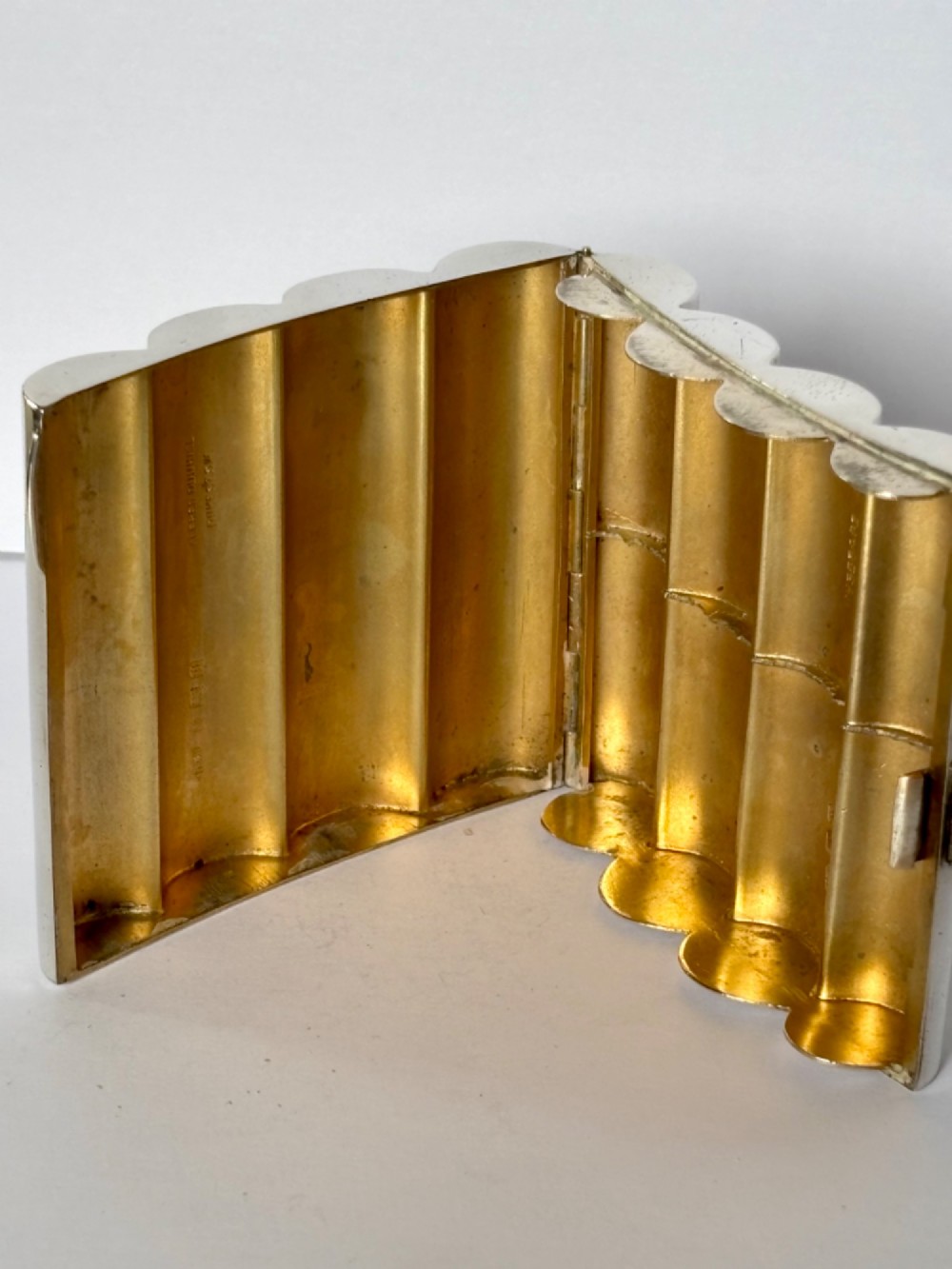 A four-tube sterling silver tobacco cartridge case with a hinged cover and smooth polished finish. View XII