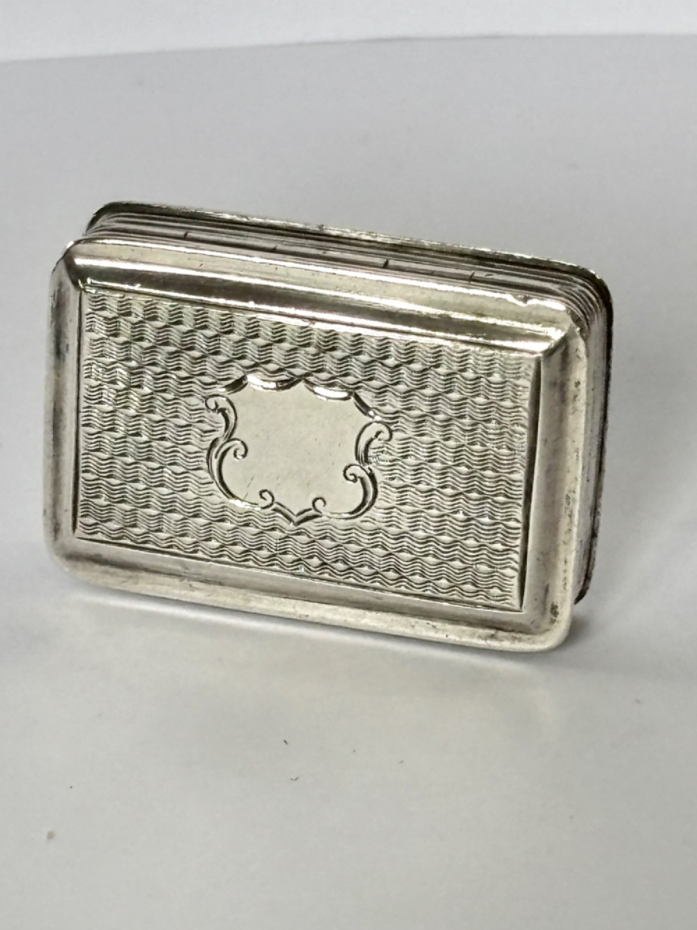 An open Early Victorian silver gilt vinaigrette showing a floral pierced interior grille and hallmarks on the inside lid. View V
