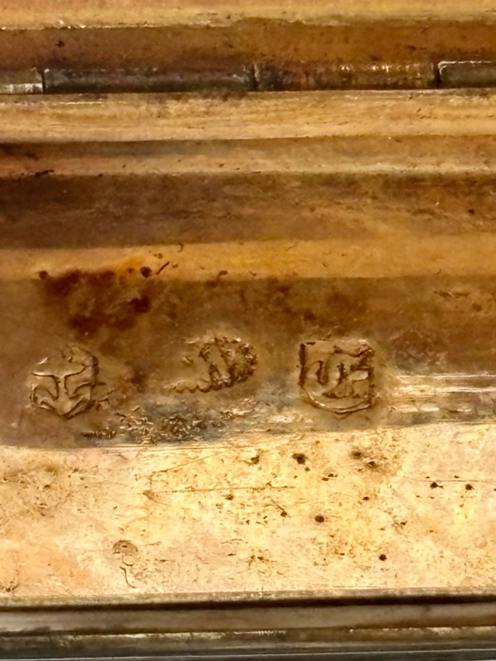 An open George IV rectangular silver-gilt vinaigrette showing internal hallmarks and a hinged pierced grille next to a small dark sponge. View VII