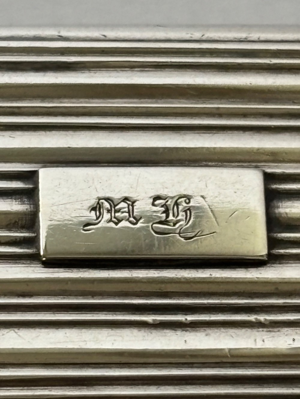 An open George IV rectangular silver-gilt vinaigrette showing internal hallmarks and a hinged pierced grille next to a small dark sponge. View XI