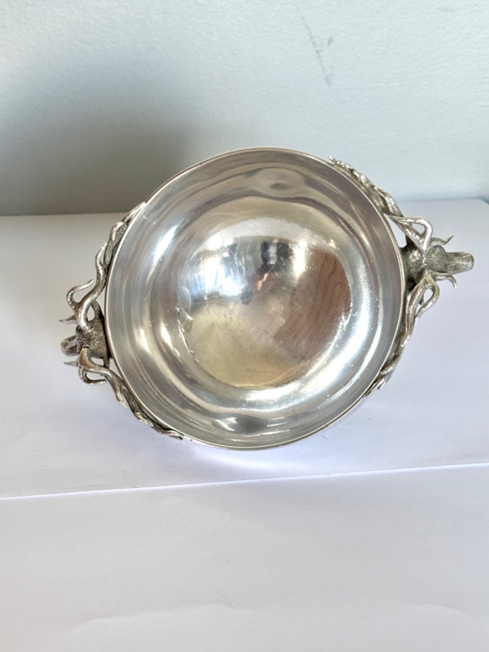 Late Victorian Scottish silver quaich featuring cast stag head handles and an engraved military presentation inscription on a circular pedestal base. View VI