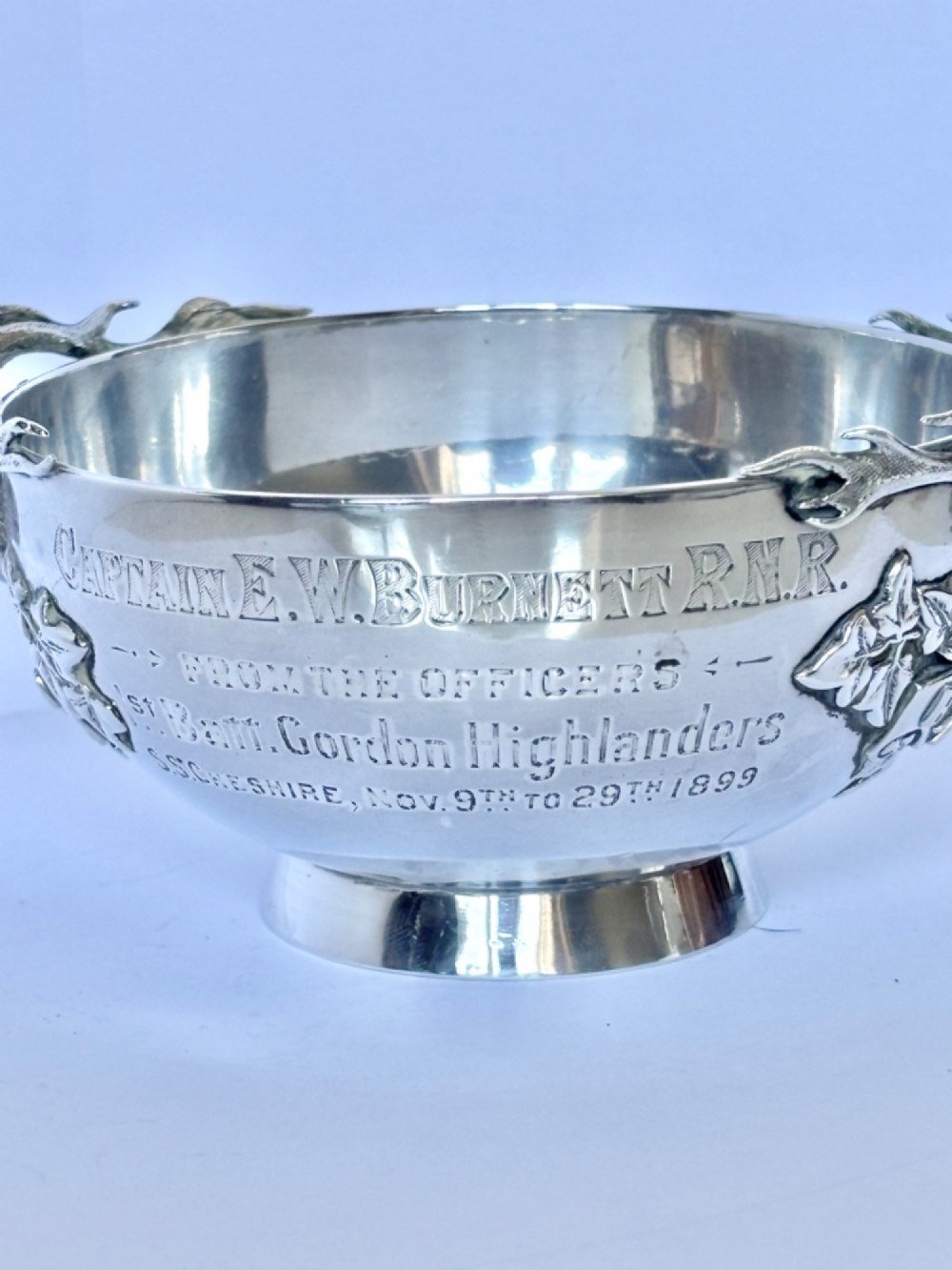 Late Victorian Scottish silver quaich featuring cast stag head handles and an engraved military presentation inscription on a circular pedestal base. View IX