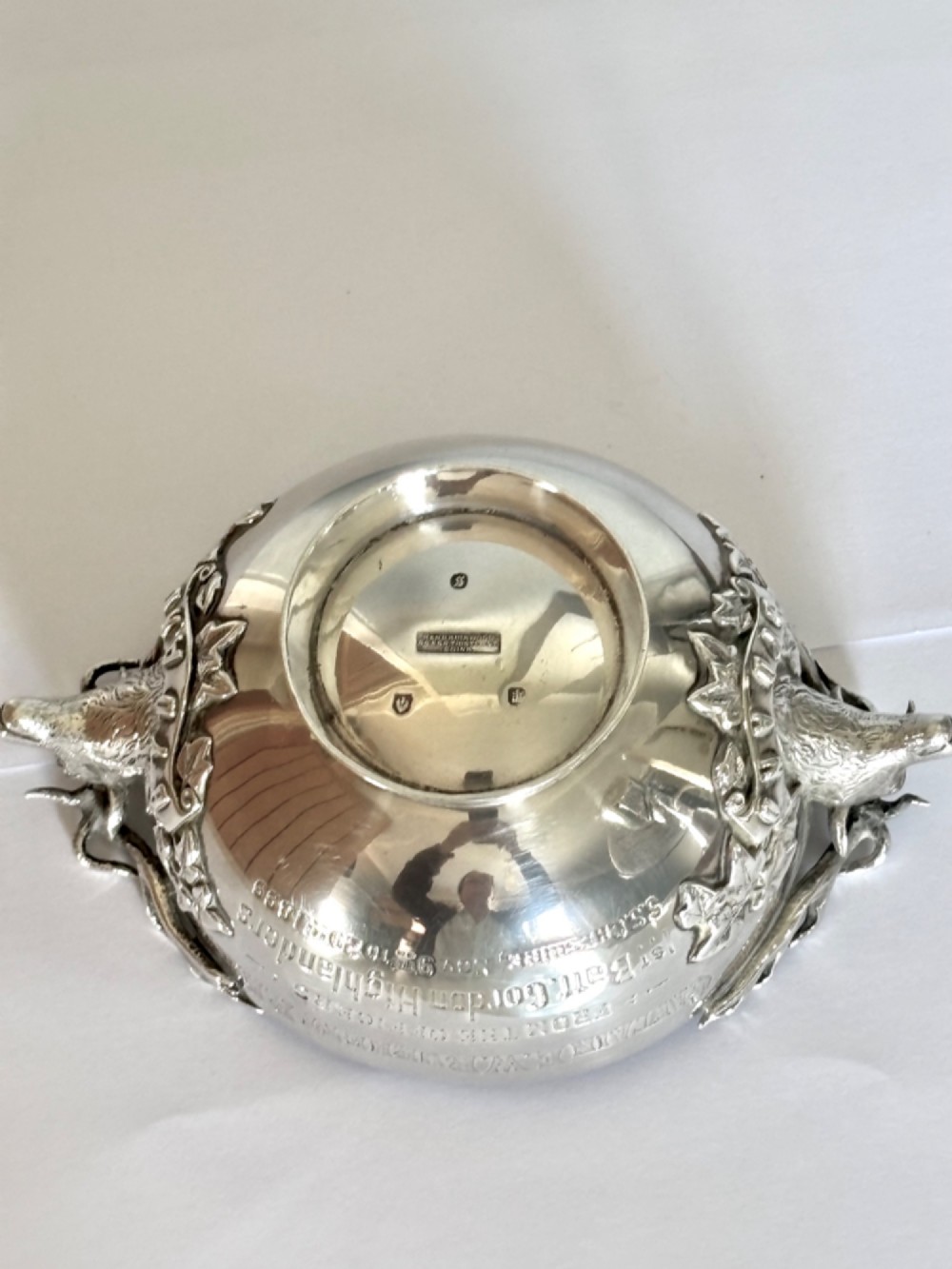 Late Victorian Scottish silver quaich featuring cast stag head handles and an engraved military presentation inscription on a circular pedestal base. View XIII