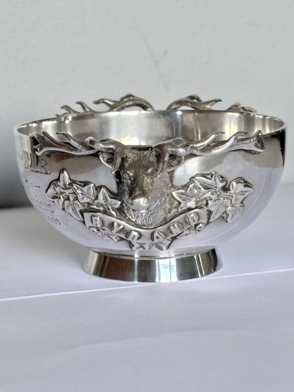 Late Victorian Scottish silver quaich featuring cast stag head handles and an engraved military presentation inscription on a circular pedestal base. View XV