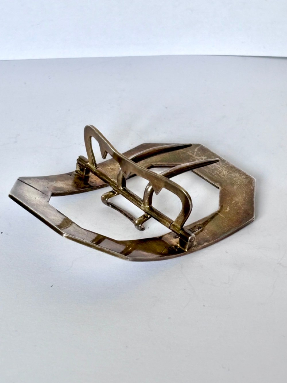 An octagonal antique silver belt buckle featuring lavender guilloche enamel bordered in white enamel with a central metal prong mechanism. View VIII